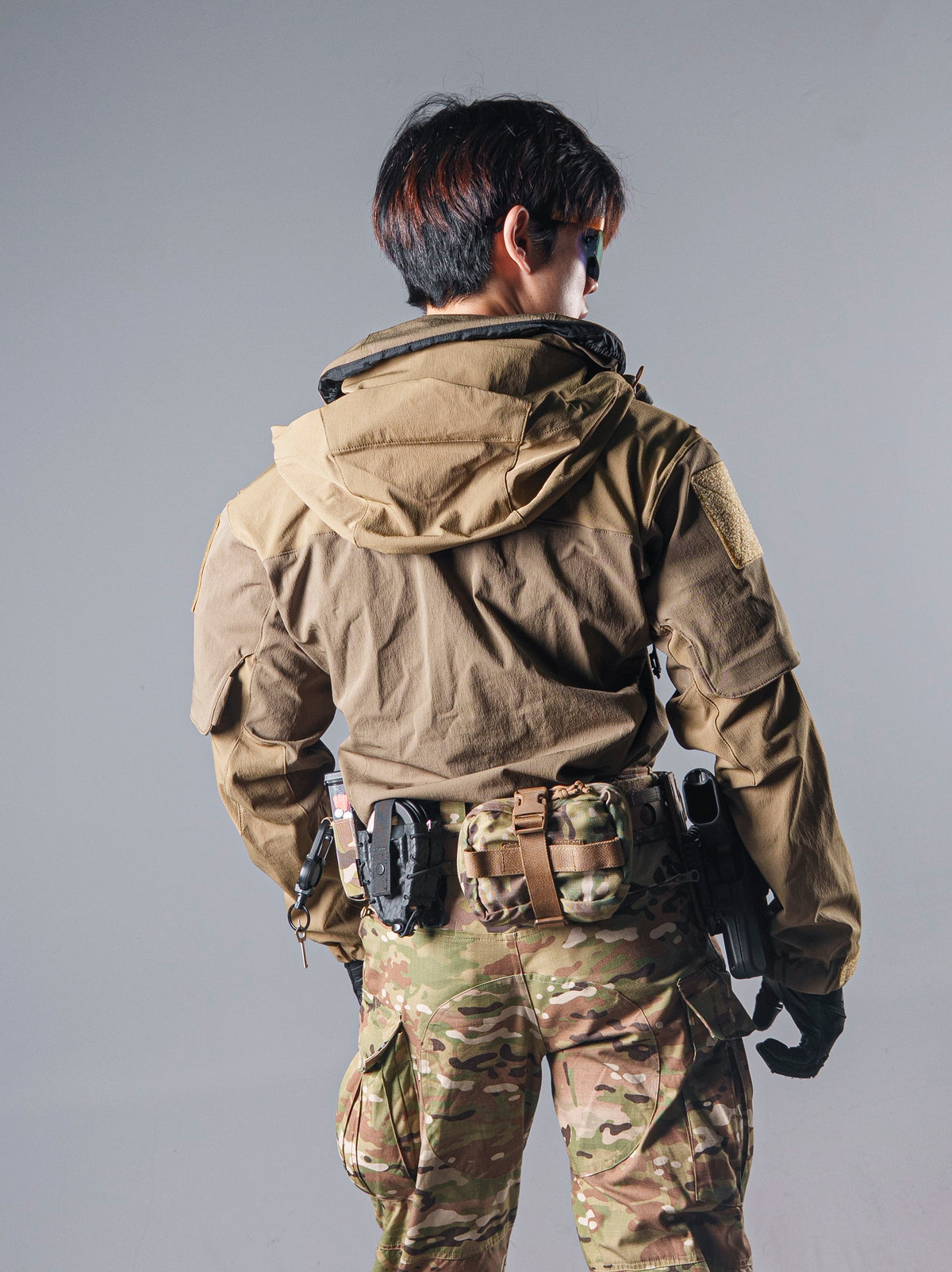 Back view of a model wearing the tan BKG ARC-style Gryphon Crocodile Halfshell Jacket with the hood and rear panel visible.