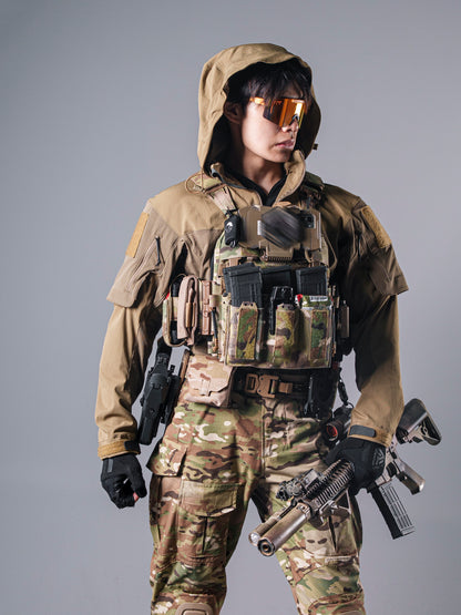 Model wearing the tan BKG ARC-style Gryphon Crocodile Halfshell Jacket with the hood up beneath a tactical chest rig.