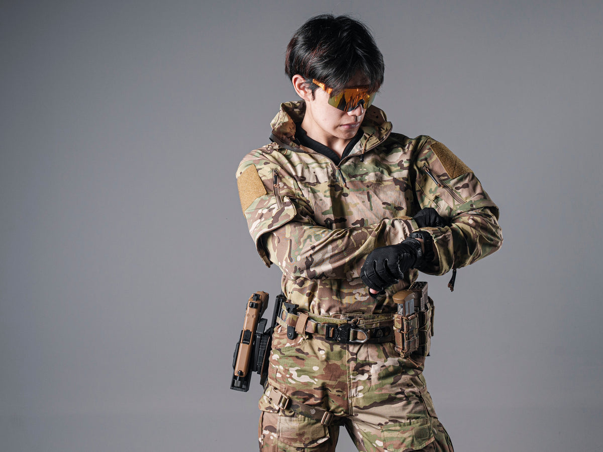 Model wearing the Multicam Gryphon Halfshell Jacket while adjusting a black glove at the wrist.