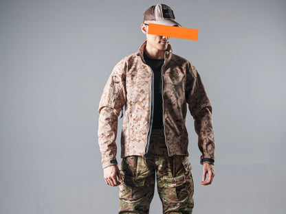 Front view of a model wearing the zipped tan AOR1 digital camouflage Minotaur softshell jacket with matching camouflage pants.